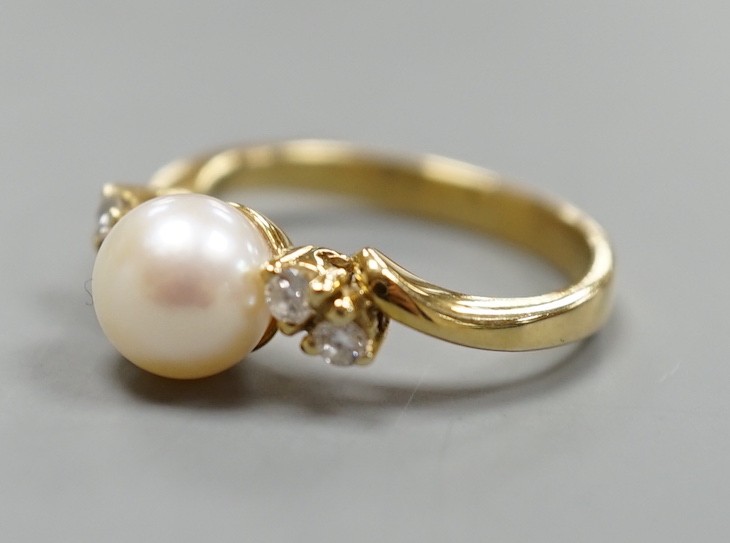 A 14kt yellow metal and single stone cultured pearl ring, with diamond set shoulders, size J, gross weight 3.4 grams.